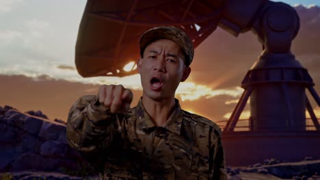 close up of asian man soldier shouting to camera while standing with satellite dish