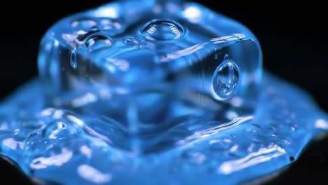 a close-up exploration of colorful ice cubes melting in vibrant liquid, showcasing the interplay of light, reflection, and surface tension