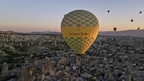 Göreme-Turkey-Aerial-v56-golden-sunrise-landscape-view,-low-level-flyover-town-capturing-fairy-chimney-rock-formations-with-scenic-hot-air-balloons-in-the-sky---Shot-with-Mavic-3-Cine---July-2022