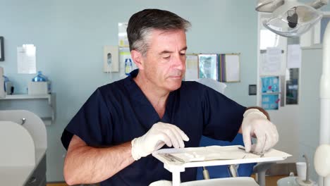 el dentista sonriente preparando herramientas