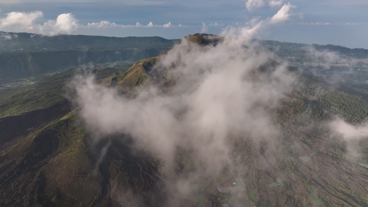 Dramatic scene over the clouds. Mt Batur active volcano in Bali, Indonesia. Drone aerial