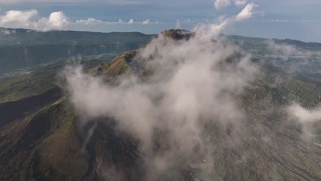 dramatic scene over the clouds. mt batur active volcano in bali, indonesia. drone aerial