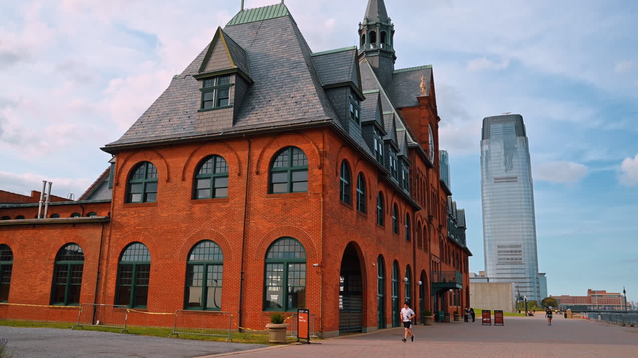 Jersey City, USA, 14 luglio 2025: Terminal in mattoni rossi del Liberty State Park con grattacielo sullo sfondo. Vista laterale dello storico terminal del Liberty State Park