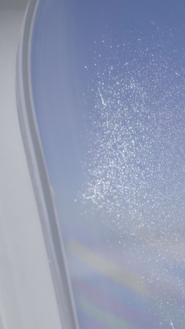 View through a plane window with frosty patterns in the sky