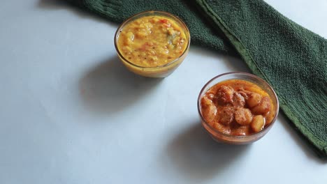 rotation chole bhature or chick pea curry and fried puri served in terracotta crockery over blue background