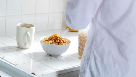 Man-pouring-breakfast-cereal-into-bowl-in-kitchen-4k