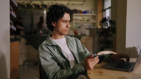 man working on laptop in cafe