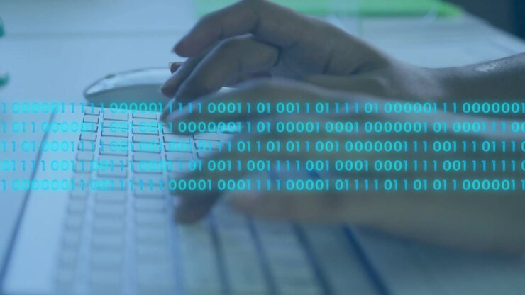 Woman typing at keyboard, using mouse, activating binary overlay visualizing tech data flow