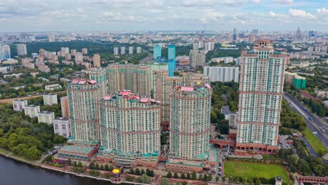 AERIAL-view-of-a-group-of-modern-stylized-skyscrapers-in-the-urban-area-next-to-the-river,-Moscow,-Russia