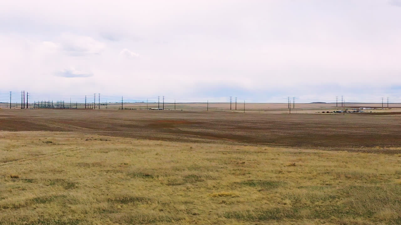 subida aérea de drones y revelación de líneas eléctricas y campos vacíos de hierba muerta en medio de la nada kansas