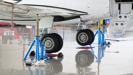 detalles de cerca del moderno tren de aterrizaje de aviones en hangar, en tomas