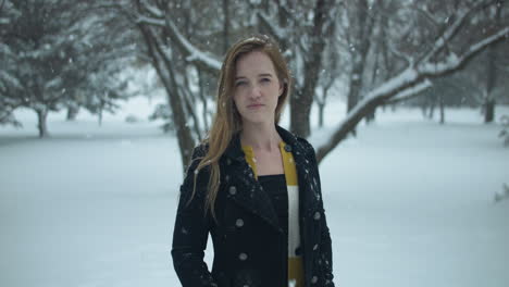 happy woman outside in slow motion winter snow as snowflakes fall in cinematic slow motion