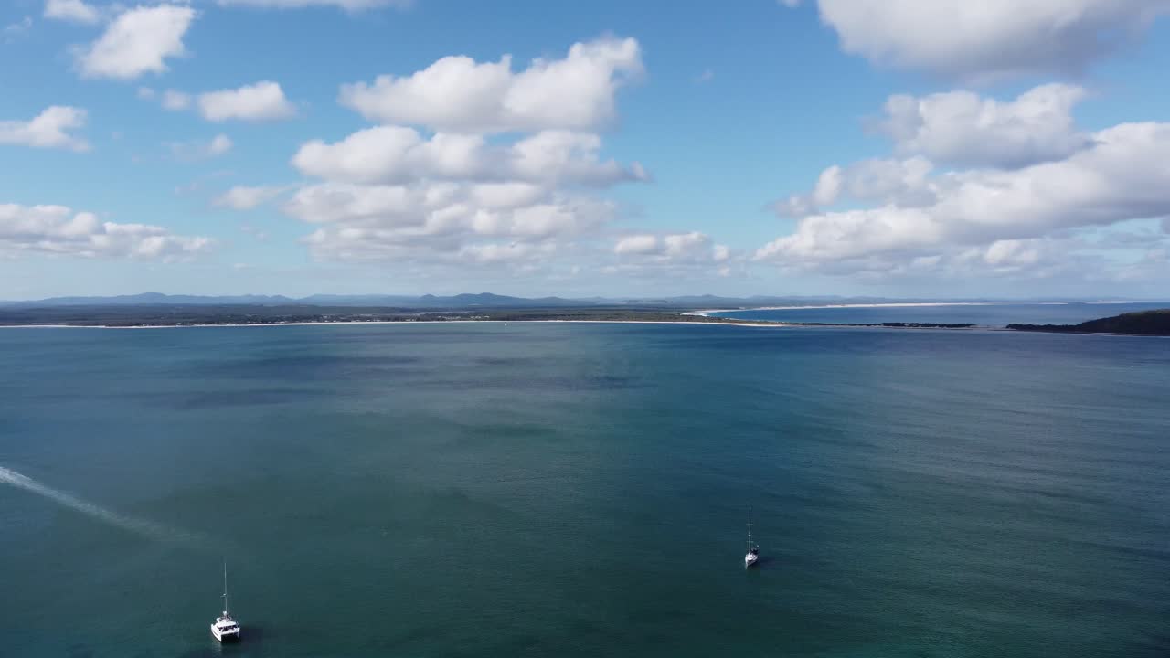 오스트레일리아 의 해안선 의 공중 전망 , 배, 모래 해변, 섬 및 산 근처 의 해안 마을 을 보여 주는 사진