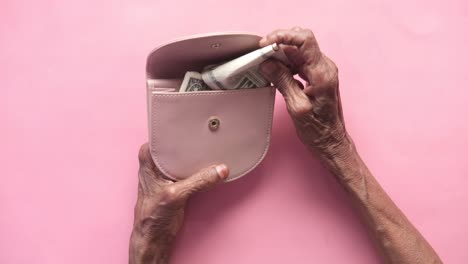 elderly hands opening a pink purse