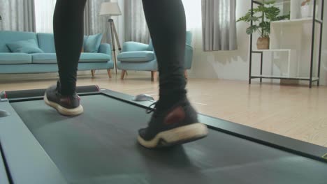 back view legs of asian woman training on walking treadmill at home