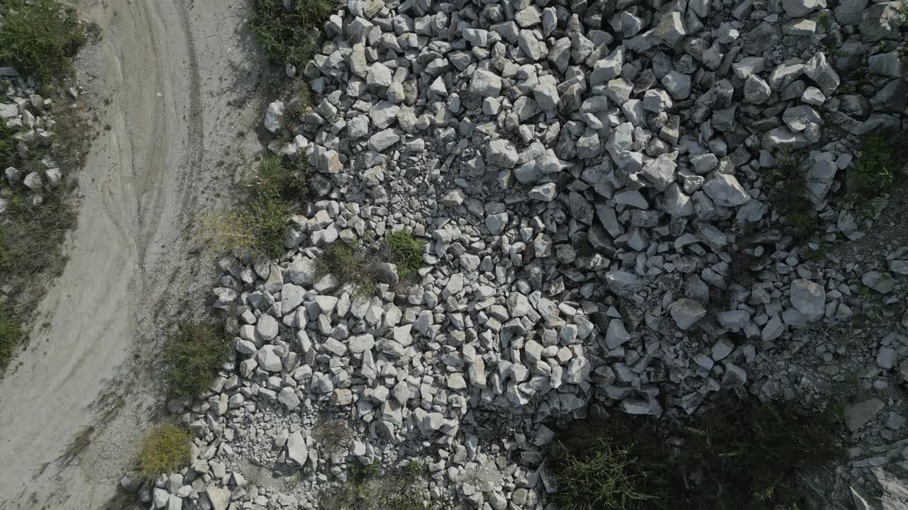 Multiple aerial views show piles of quarry stones and gravel in an extraction site, highlighting the industrial processes and environmental impact of resource gathering