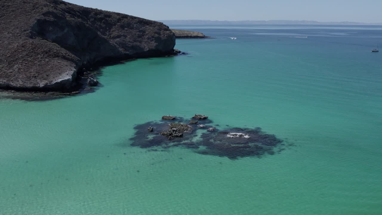 Tilt down over rocks in middle of the sea in Balandra Beach
