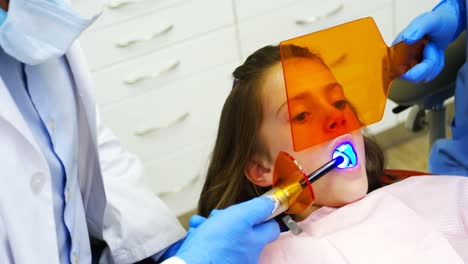 dentists examining a young patient with tools