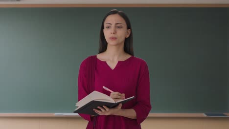 Indian-female-teacher-taking-attendance-in-school