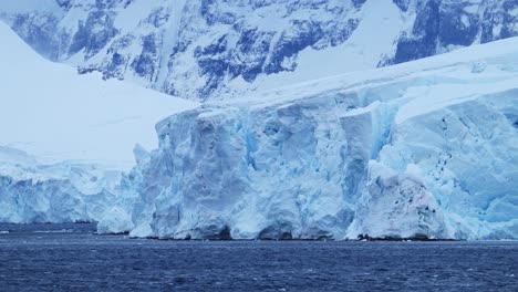 Glacier-and-Ice-Close-Up-by-Ocean-in-Antarctica-on-the-Coast,-Coastal-Winter-Scenery,-Icy-Glacial-Landscape-with-Large-Glacier-Next-to-the-Sea-on-Antarctic-Peninsula-with-a-Crevass-and-Ice-Formations