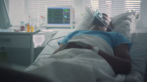 el paciente enfermo respira una máscara de oxígeno en la sala de emergencias. interior moderno de la sala del hospital