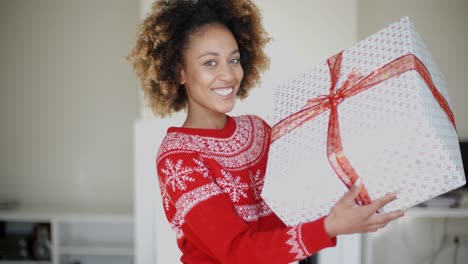 happy smiling girl with afro haircut holding gift