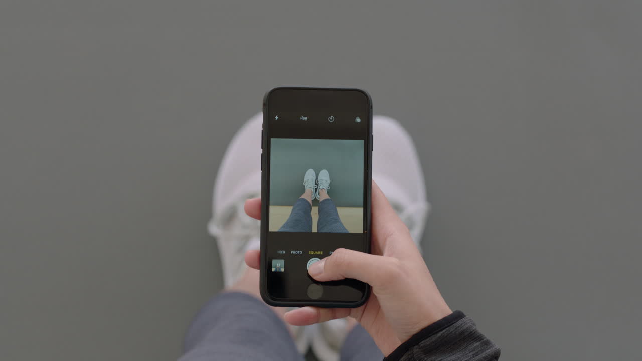 vista de arriba manos de mujer usando un teléfono inteligente tomando una foto de zapatos nuevos compartiendo fotografía en las redes sociales disfrutando de la moda elegante