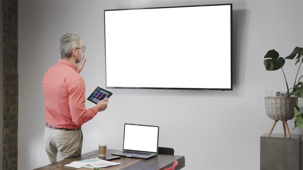 un hombre de negocios caucásico en una llamada de video con una pantalla de televisión en blanco.