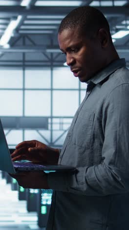 vertical video portrait of happy system administrators in data center using devices