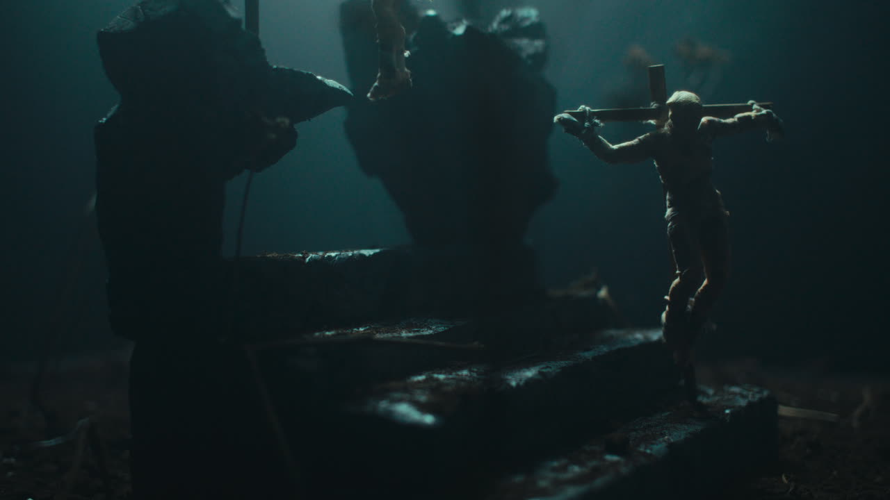 A miniature mummified doll hanging on the gallows at night