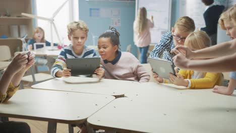 elementary school computer science class: children use digital tablet computers and smartphones with augmented reality software, they're excited, full of wonder. children in stem, playing and learning