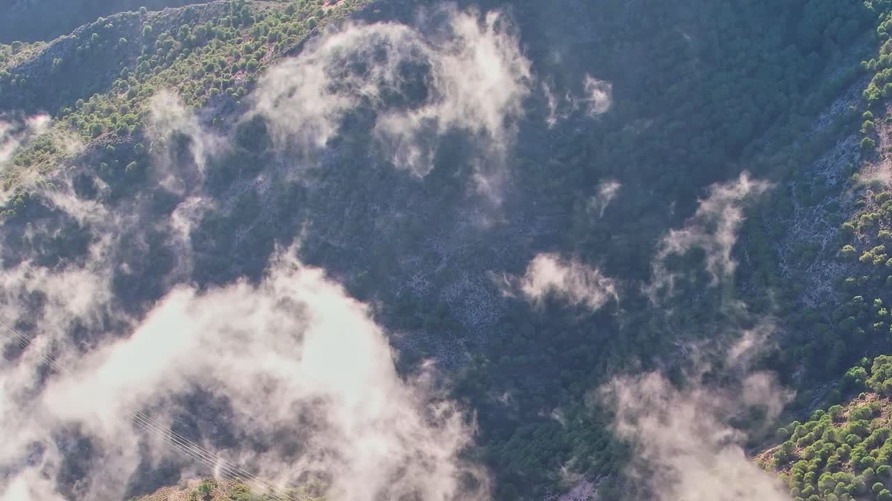 スペインのマラガ、緑の丘を覆うように雲が流れる早朝の風景。