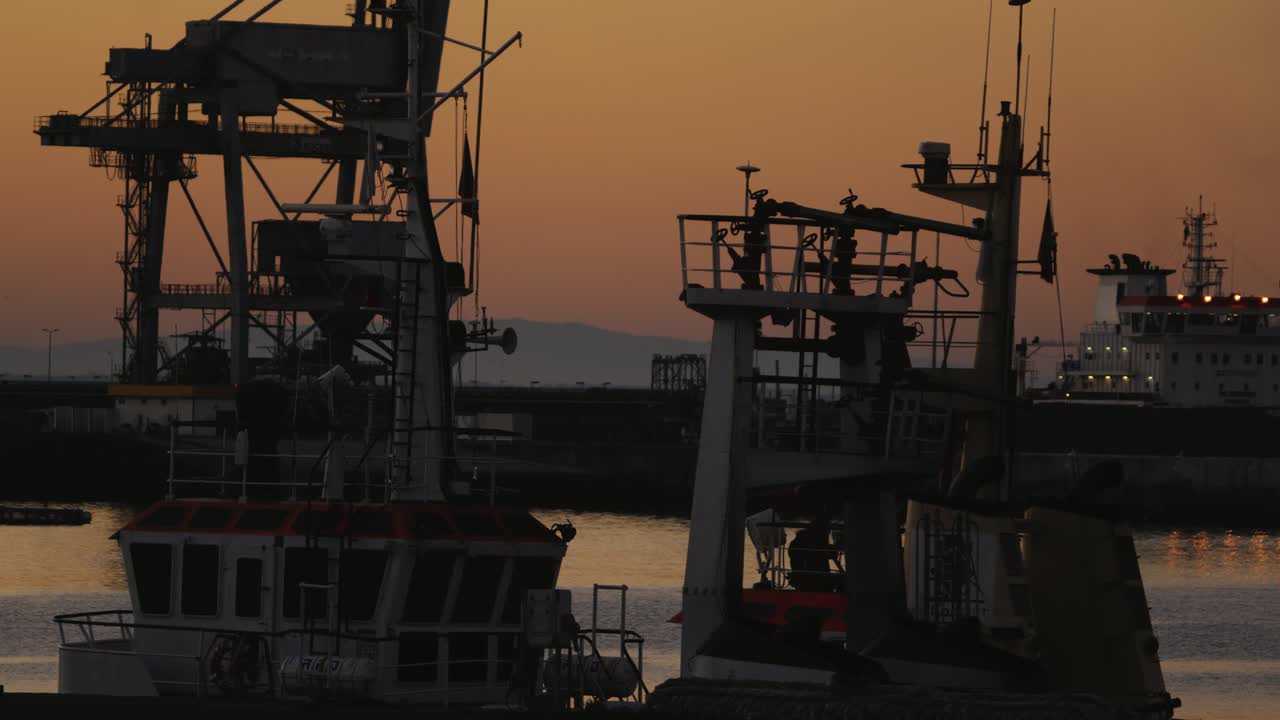 puerto de senos o puerto en portugal, barcos y grúas, romántico cielo naranja al atardecer