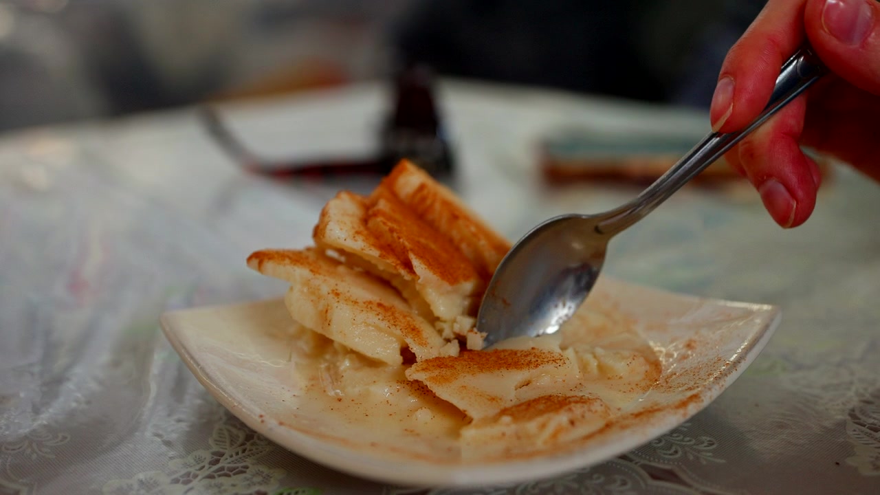 Kaşıkla yenen geleneksel tarçınlı sütlü dondurma Queso helado'nun elde yakın çekimi. Bu otantik Peru tatlısı, Peru'nun Arequipa şehrinde ünlü bir mutfak spesiyalitesidir.