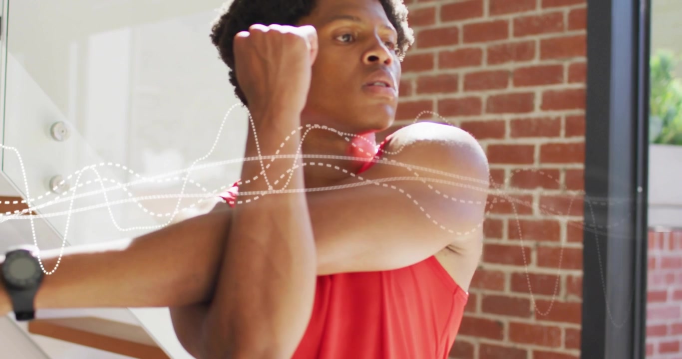 Man by brick wall glass door holding arms activating waveform overlay stretching shoulder,triceps