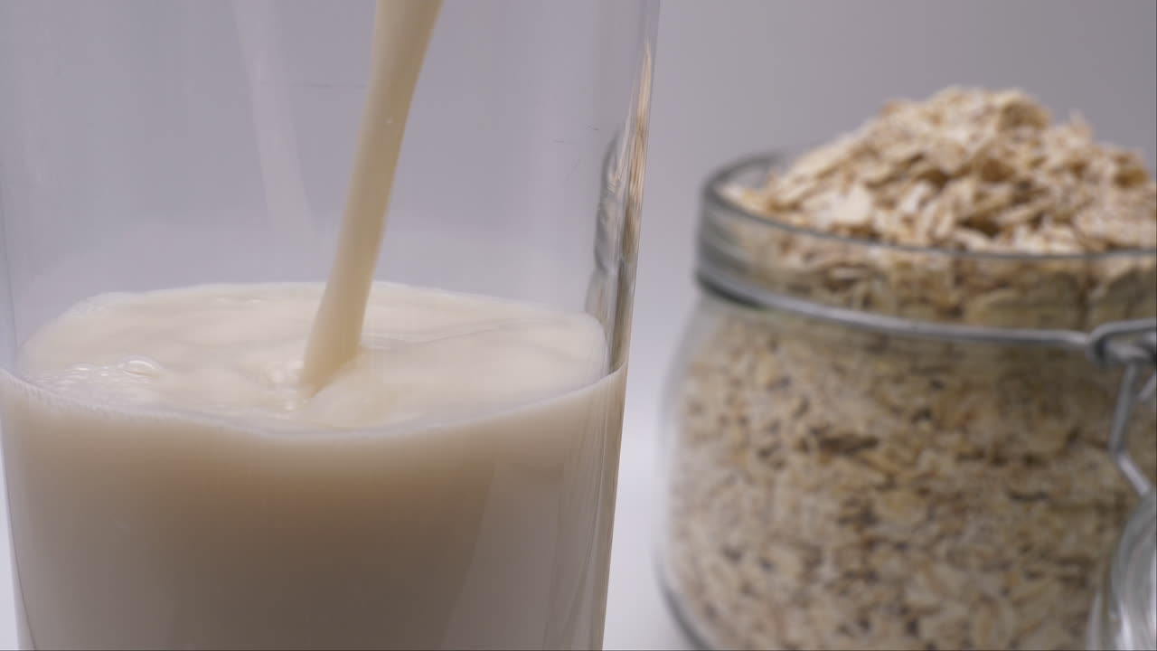 alternativa de leche no láctea vertiendo un vaso de leche de avena