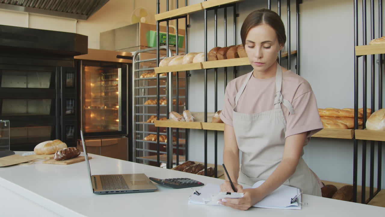 Woman Working behind Counter in Bakery