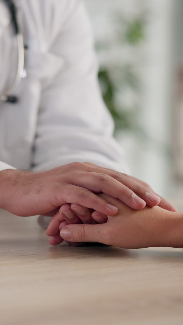 Doctor comforting patient with hand on hand