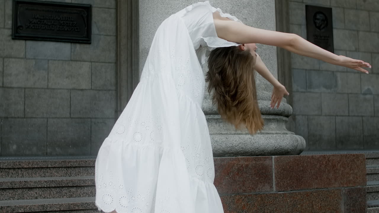 Woman in white dress posing in front of a building