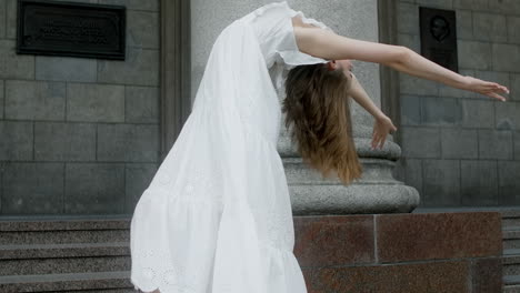 woman in white dress posing in front of a building