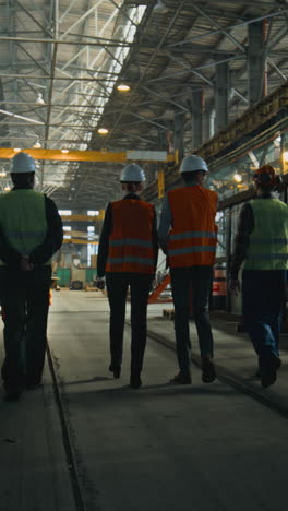 trabajadores de la fábrica caminando por un almacén