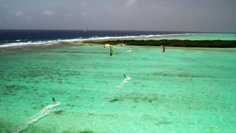 Kitesurfer-Gleiten-über-Das-Leuchtend-Türkisfarbene-Wasser-Von-Buchillaco,-Los-Roques,-Luftaufnahme