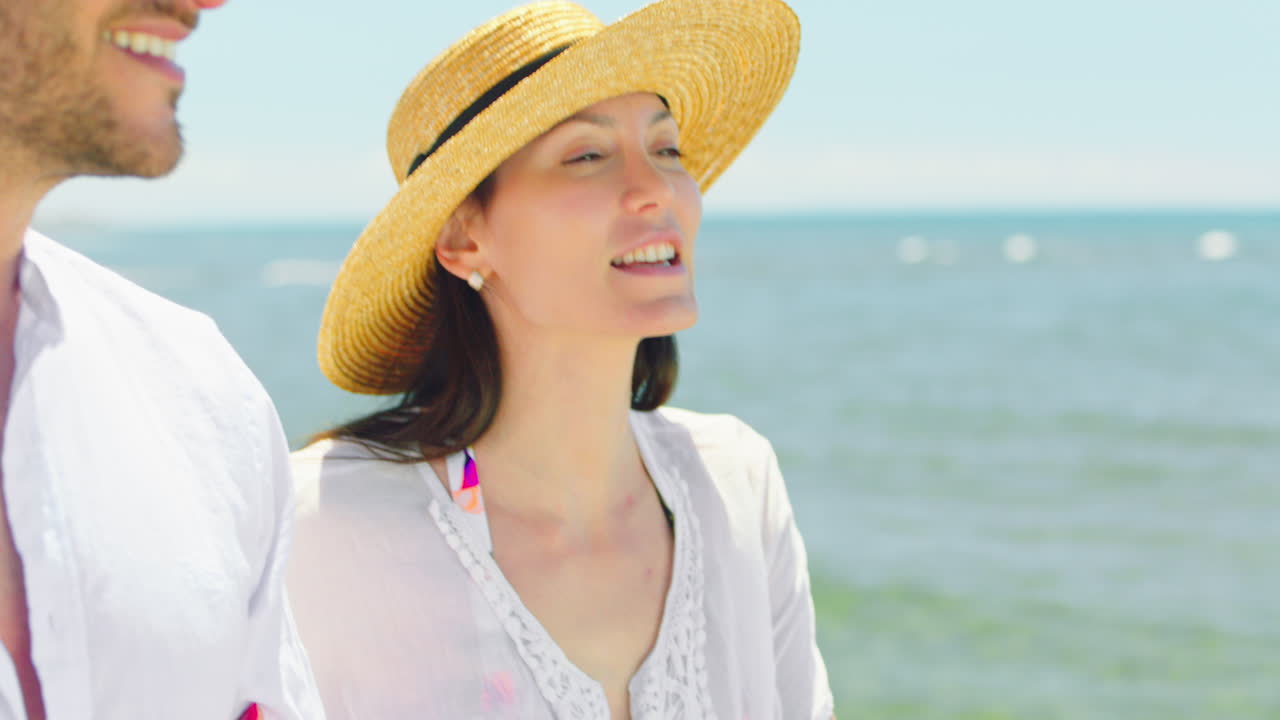 해변 에서 빛 이 넘치는 날 을 즐기는 부부