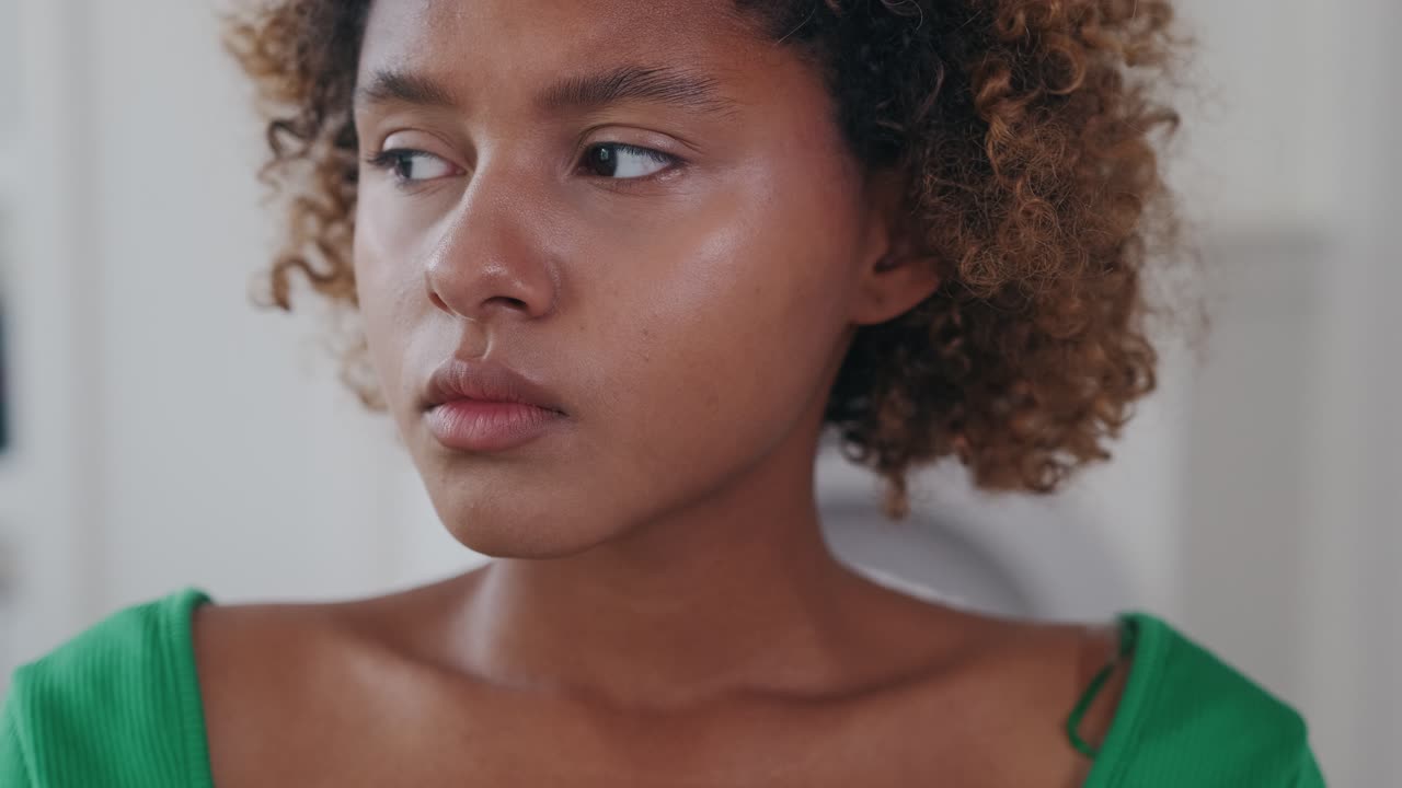 Young puzzled african american woman nervously typing email message on phone