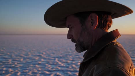 man in cowboy hat at sunset on a salt flat