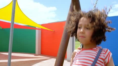 vista frontal de una escolar de raza mixta jugando en el patio de recreo de la escuela en un día soleado 4k