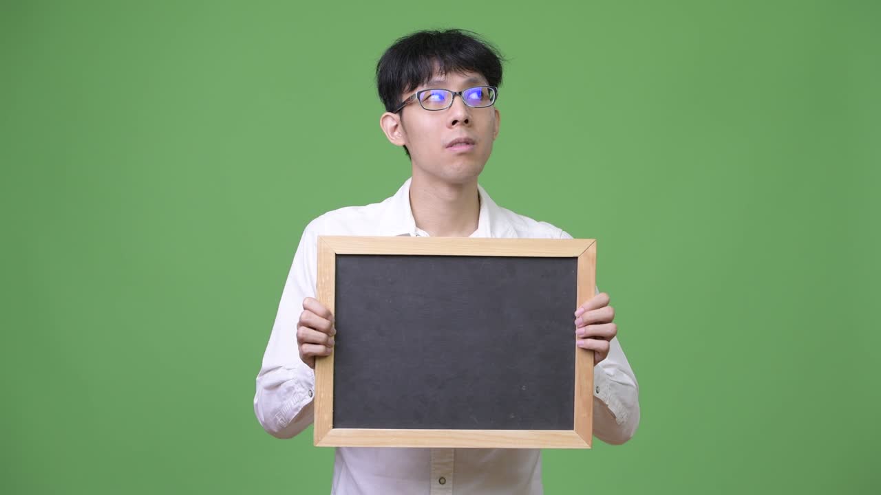 생각 하는 동안 검은판 을 들고 있는 젊은 아시아인 사업가