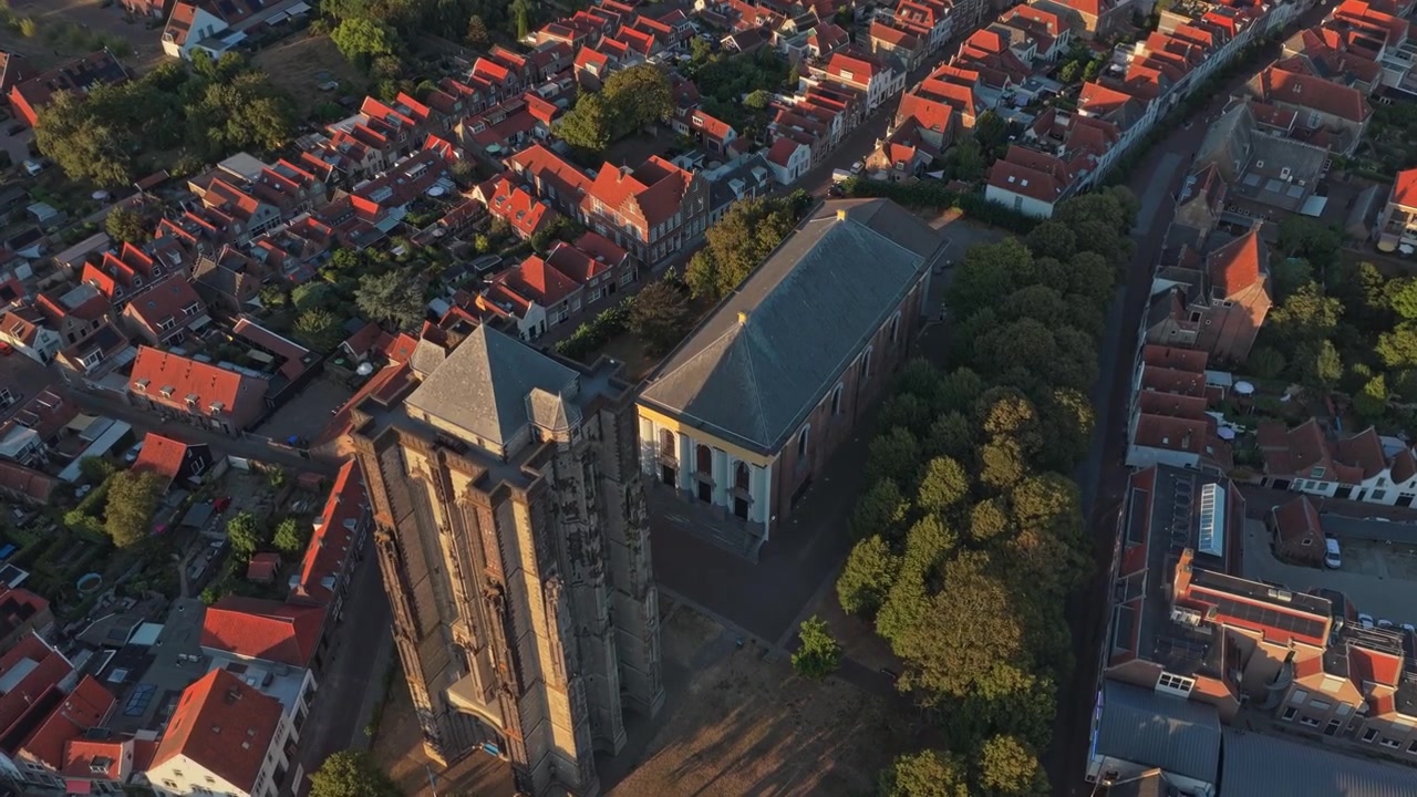 Luftfoto af historisk kirke og by ved solnedgang
