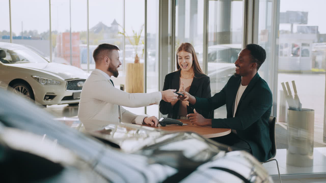 concesionario de automóviles - clientes felices que reciben las llaves del coche