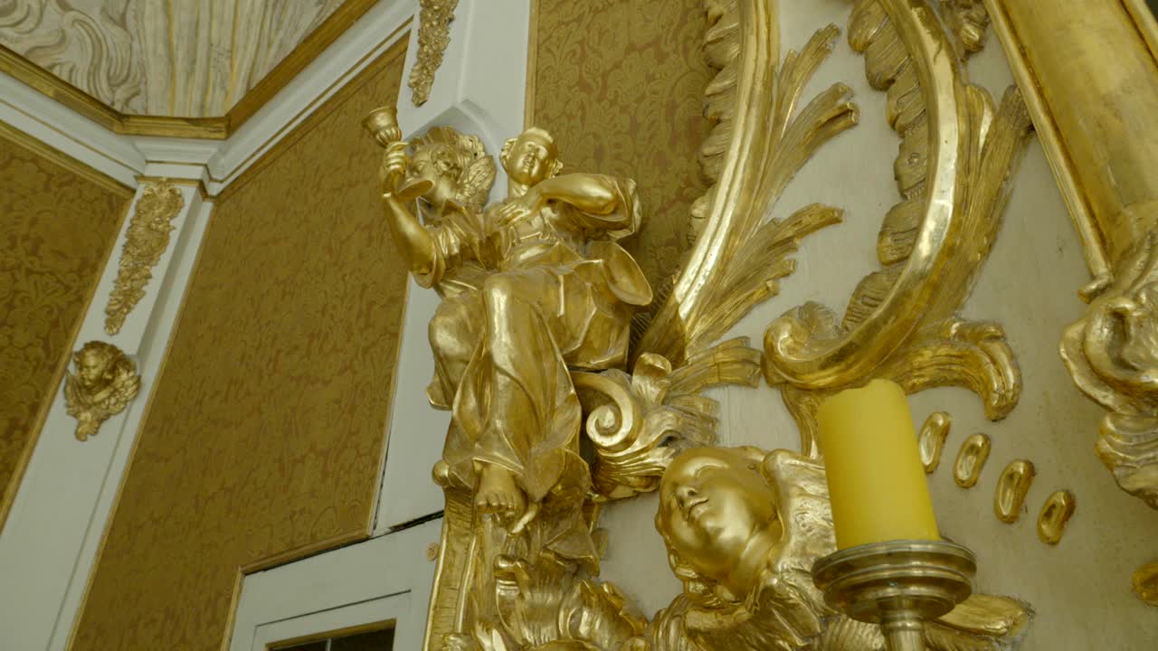 Golden sculptures that are part of the altar in the chapel, located on a richly decorated wall
